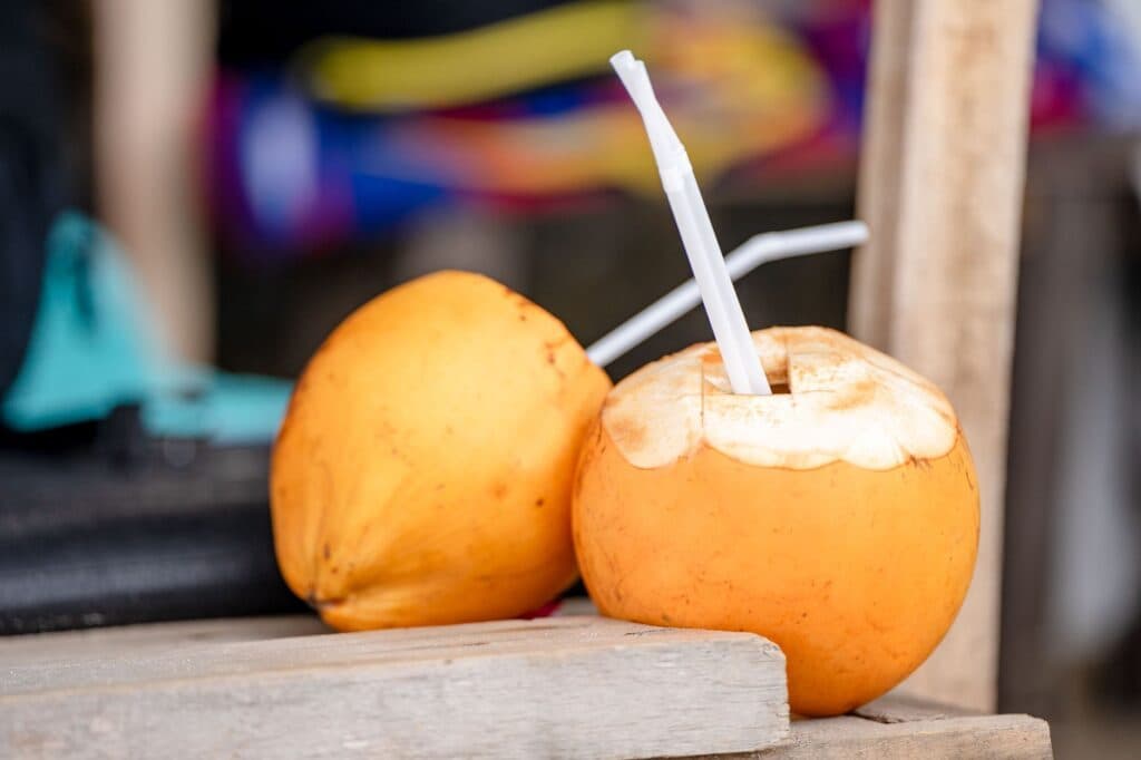 Cocos frescos com canudinhos, prontos para beber a água de coco