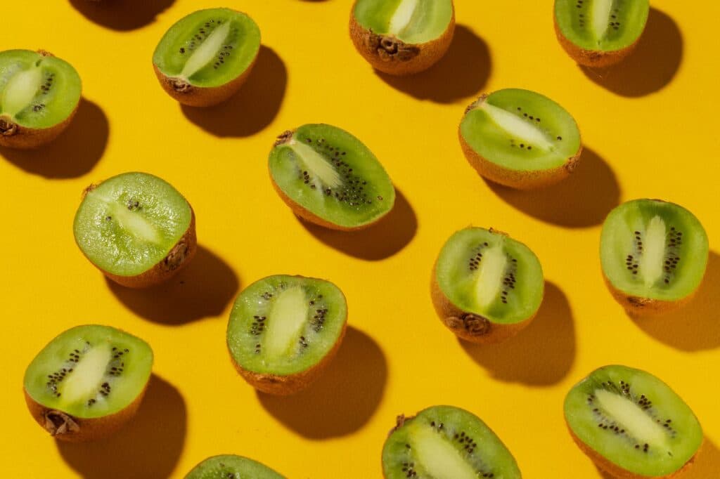 Kiwis frescos cortados em rodelas, com a polpa verde e sementes pretas à mostra