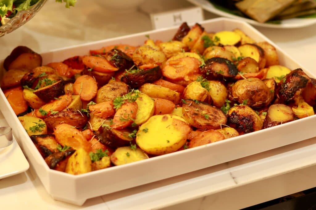 Batatas e cenouras assadas com ervas em uma assadeira