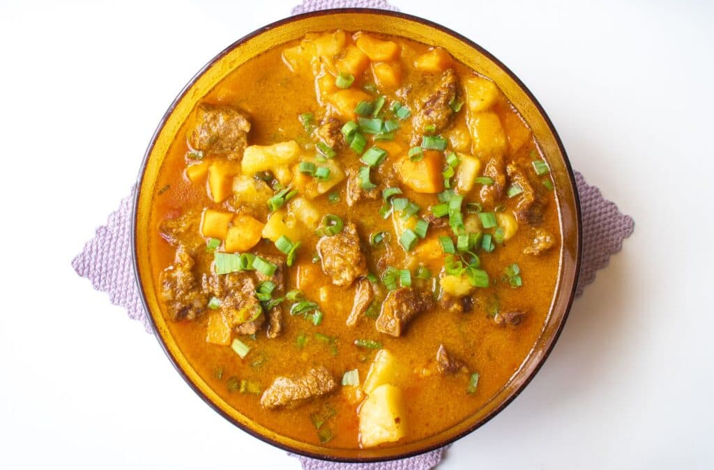 Picadinho de carne com batatas e cebolinha servido em uma tigela