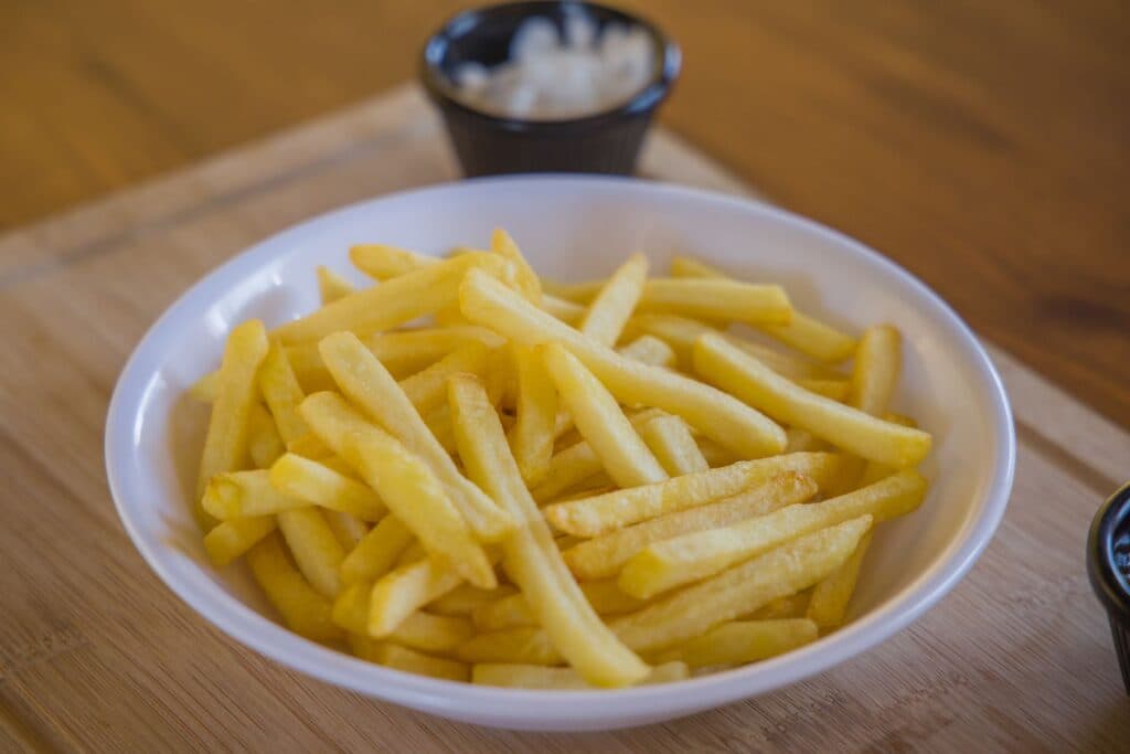 Batatas fritas douradas e crocantes em uma tigela de cerâmica