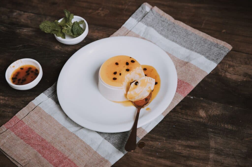Sobremesa de maracujá decorada com sementes e hortelã