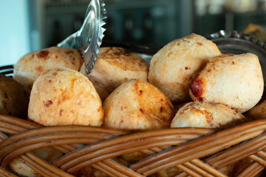 Pães de queijo recém-assados em uma cesta de palha