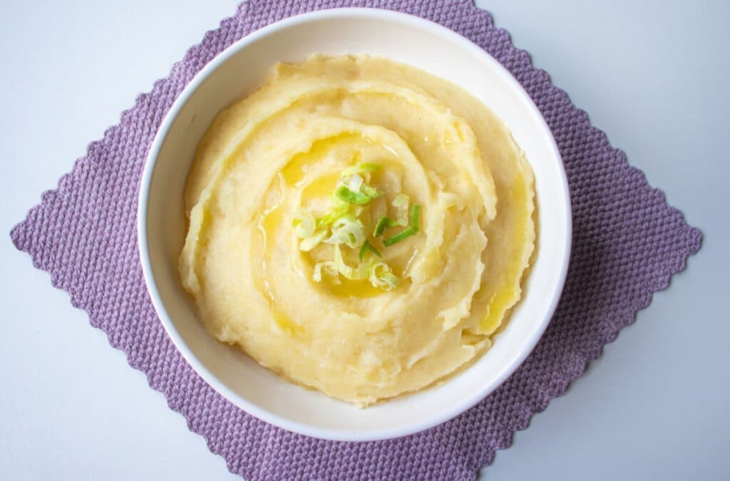 Purê de batata cremoso com cebolinha em uma tigela branca
