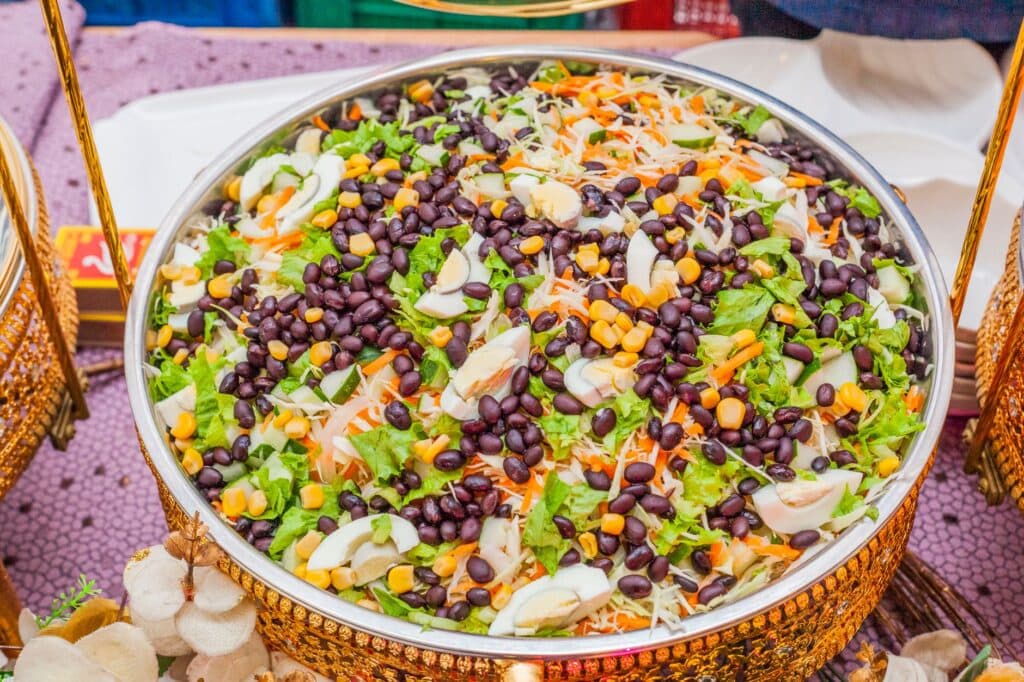 Salada colorida de feijão preto, milho e repolho em uma tigela decorada