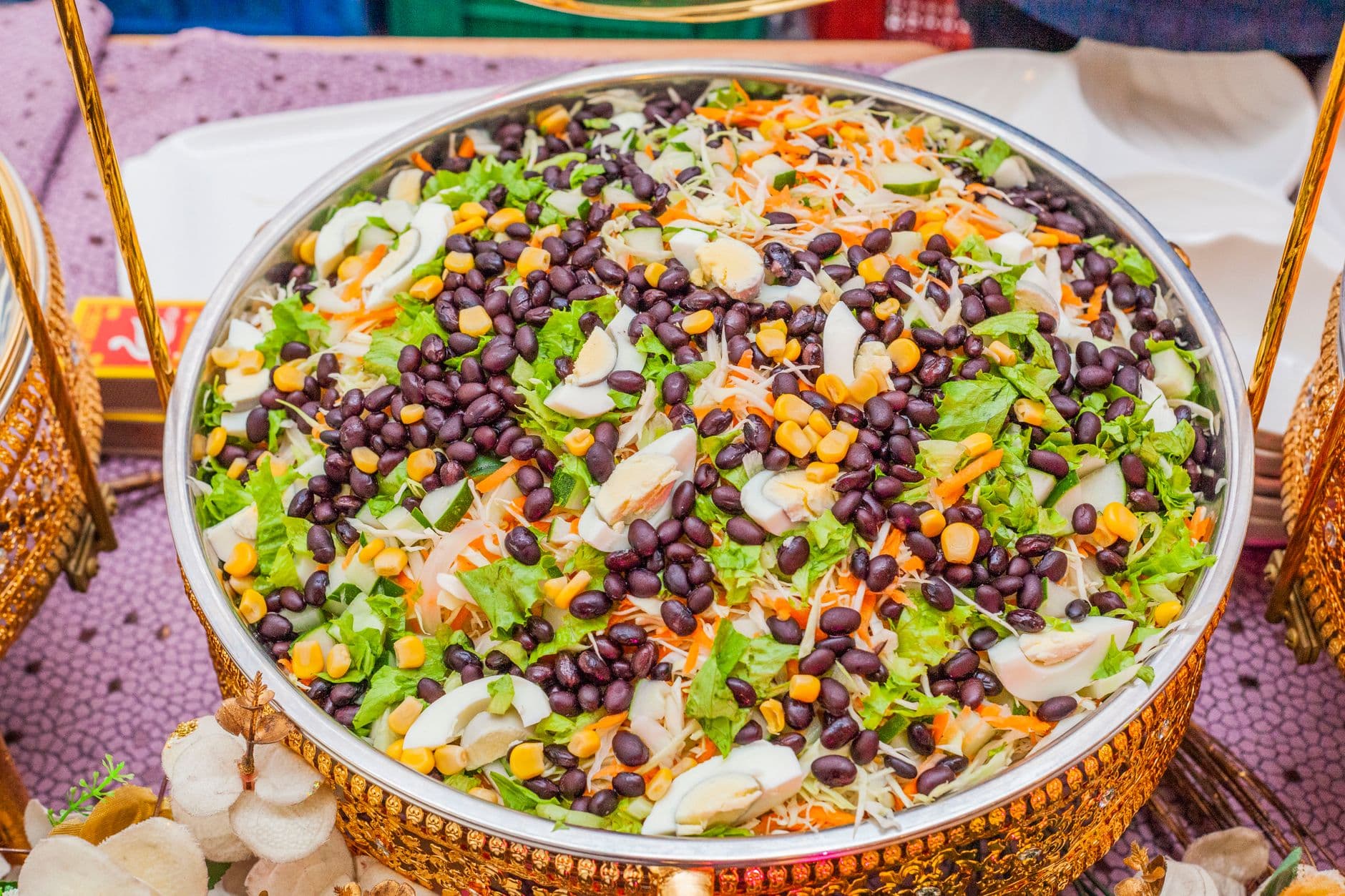 Salada colorida de feijão preto, milho e repolho em uma tigela decorada